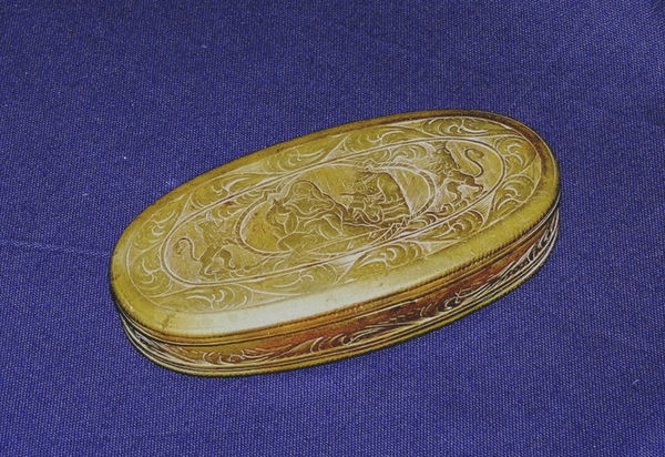 Diese ovale Tabakdose aus Messing ist eine holländische Arbeit und datiert in das 18. Jahrhundert. Der Deckel und Boden sind flächig mit gravierten Bildmotiven verziert, darunter wahrscheinlich eine Darstellung der Heiligen Familie im Tempel.