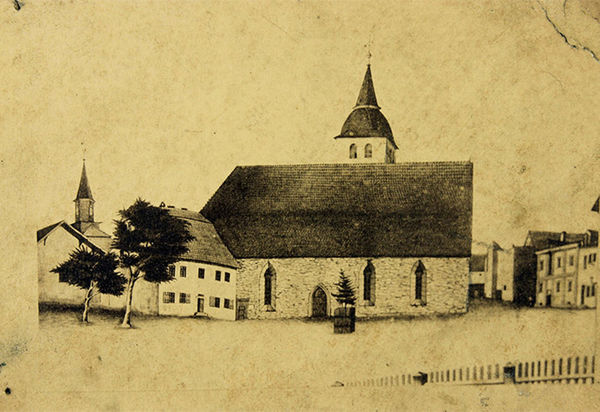 Pappe aus mehreren Lagen dickem Papier, darauf Fotografie. Motiv: Zeichnung der alten Stadtkirche St. Katharinen zu Wolmirstedt im Zustand nach 1740. Rückseite mit handschriftlicher Notiz in schwarzer Tinte: "Willi Ulrich // Wolmirstedt // Ganggasse 1" sowie Zeichnung eines Gesichts.